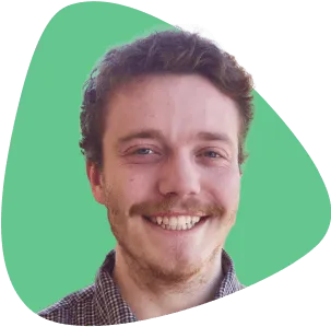 Cathal O’Dea, smiling, with a mustache and beard.