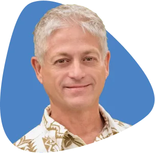 Farris Etterlee, smiling, with grey hair and wearing a patterned shirt.