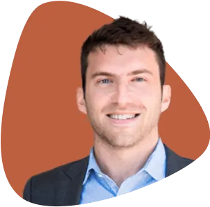 Zachary Ginsburg, smiling, wearing a suit jacket and blue shirt.