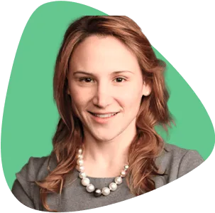 Emilie Poteat, smiling, with long hair and wearing a pearl necklace.